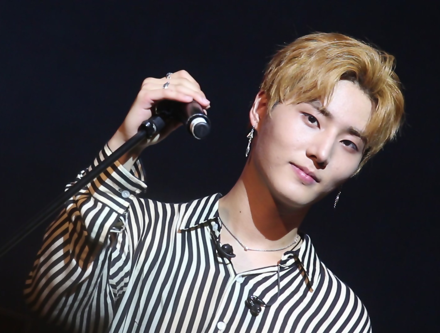 Young K singing into a microphone on stage